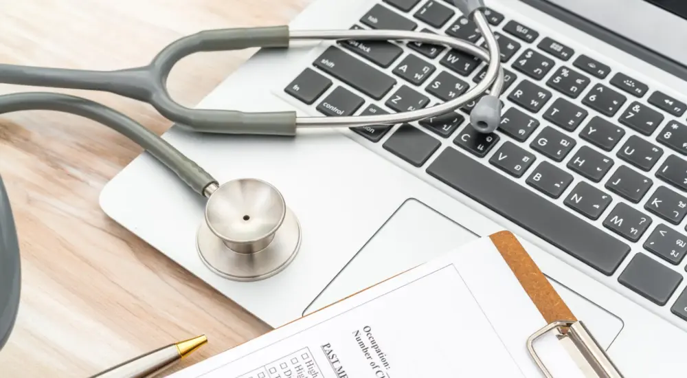 Stethoscope and prescription on laptop.